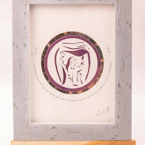 May include: A framed print with a purple and gold design featuring a woman holding a challah. The print is on a wooden easel and has the text "The challah is a symbol of the Sabbath and the cycle of life. It is a reminder that we are always connected to something greater than ourselves."