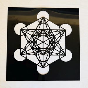 Puede incluir: Un diseño geométrico en blanco y negro con un patrón circular. El diseño es un símbolo de geometría sagrada conocido como el Cubo de Metatrón.