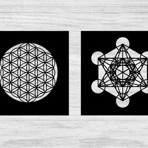May include: Two black square art prints featuring geometric designs. One print displays a white Flower of Life pattern within a circle. The other showcases a Metatron's Cube design with interconnected lines and circles.