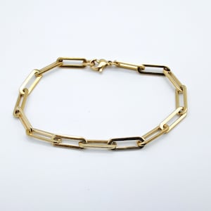 Op de afbeelding: Een gouden kettingarmband met een eenvoudig, gekoppeld ontwerp. De armband is gemaakt van metaal en heeft een sluiting.