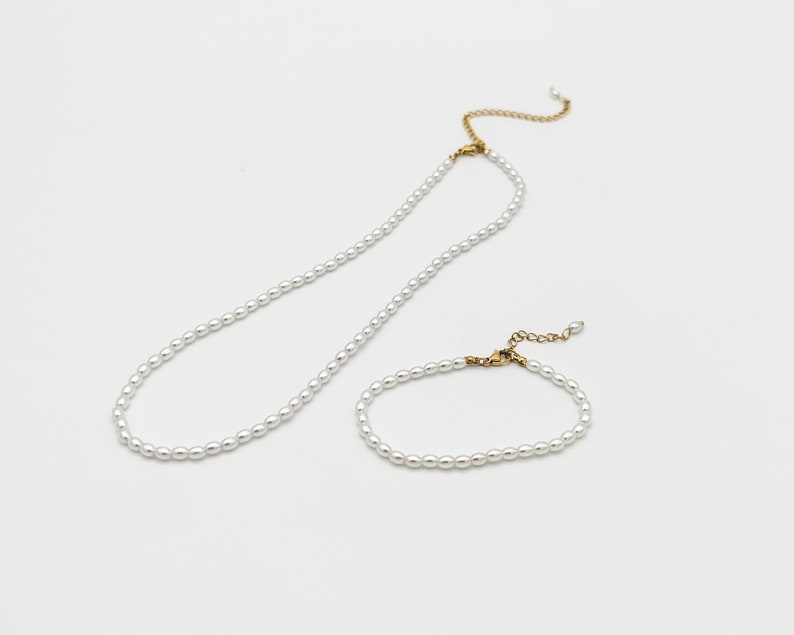 May include: A set of two pearl necklaces, one long and one short, with gold clasps.