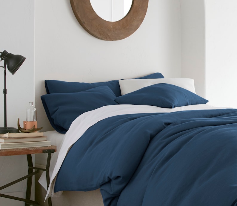 Puede incluir: Una funda n&oacute;rdica azul con fundas de almohada blancas. La funda n&oacute;rdica est&aacute; hecha de una tela suave y c&oacute;moda y tiene un aspecto relajado y casual.