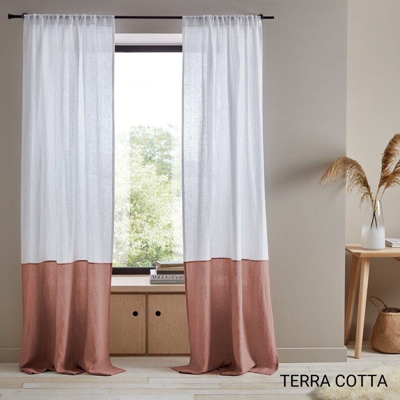 May include: Two white linen curtains with a terracotta colored bottom panel. The curtains are hung on a black rod and are in front of a window. The text "TERRA COTTA" is visible at the bottom of the image.
