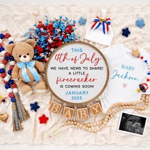 May include: A white onesie with the text "BABY Jackson" in blue lettering and a red heart. A sign with the text "THIS 4th of July WE HAVE NEWS TO SHARE! A LITTLE firecracker IS COMING SOON! JANUARY 2025" is in the background.  The onesie is surrounded by red, white, and blue decorations, including a teddy bear, a pacifier, and a baby rattle.