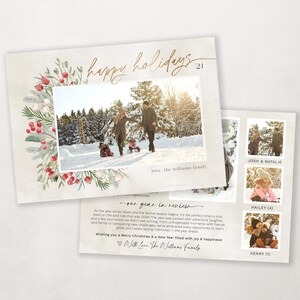 May include: A Christmas card with a watercolor wreath of red berries and green leaves. The card features a photo of a family in a snowy forest. The text "happy holidays 21" is written in gold script. The back of the card has a message about the family's year in review.