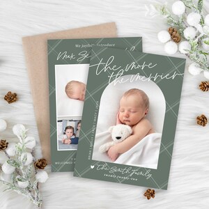 May include: A green and white plaid Christmas card with the text "The more the merrier" and a photo of a baby holding a white teddy bear. The card also includes the text "The Smith Family" and "Twenty Twenty-Two".