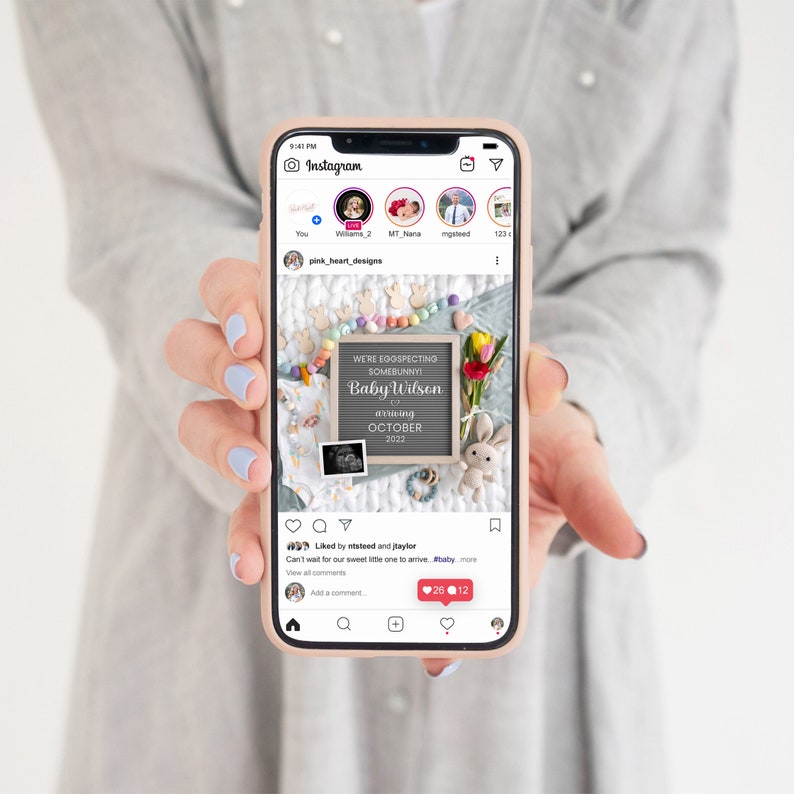 May include: A phone screen displaying an Instagram post announcing a baby's arrival. The post features a chalkboard with the text "We're expecting somebunny! Baby Wilson arriving October 2022". The chalkboard is surrounded by pastel-colored Easter eggs and a bouquet of flowers.