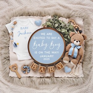 May include: A blue and white letter board with the text "We are excited to say a Baby Boy is on the way! January 2025".  The letter board is surrounded by a white onesie with the text "Baby Jackson", a blue and white teddy bear, and wooden blocks that spell out "Baby".