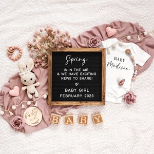 May include: A pink and white baby announcement with a letter board that reads "Spring is in the air & we have exciting news to share! Baby Girl February 2025". There are also wooden blocks that spell out "BABY" and a pink and white onesie with the name "Madison" written on it.
