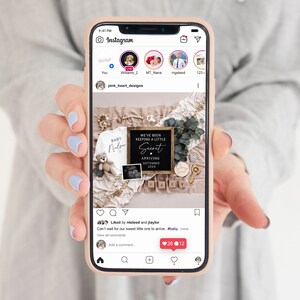 Op de afbeelding: Een zwart ingelijst bord met de tekst "We've been keeping a little secret. Arriving September 2024."  Het bord is omringd door babyartikelen, waaronder een rompertje, een teddybeer en een houten blok met de tekst "Baby".