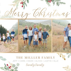 May include: A Christmas card featuring a family of seven standing in a field. The card has a gold border and a watercolor design of greenery and red berries. The text "Merry Christmas" is written in gold script at the top of the card. The text "The Miller Family" is written in gold script below the photo. The names of the family members are listed below the family name, followed by the year "Twenty Twenty".