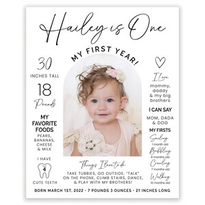 May include: A white and black printable first birthday milestone poster with a photo of a baby girl. The poster includes the baby's name, Hailey, age, height, weight, favorite foods, first words, and milestones. The poster is decorated with a heart and a tooth.