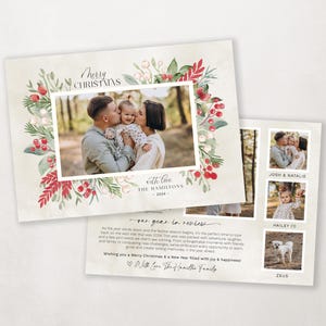 Pode incluir: Um cart&atilde;o de Natal com uma coroa de aquarela de folhagem e bagas vermelhas. O cart&atilde;o apresenta uma foto de fam&iacute;lia de um casal e seu filho, junto com uma mensagem que diz "Feliz Natal com amor The Hamilton's - 2024 -" e uma se&ccedil;&atilde;o de resumo do ano.