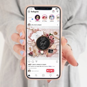 May include: Instagram post announcing the arrival of a baby girl. The post features a black and white sign with the text "We are having a baby girl" and the date "August 2024". The sign is surrounded by pink flowers, a baby onesie, and other baby-related items.