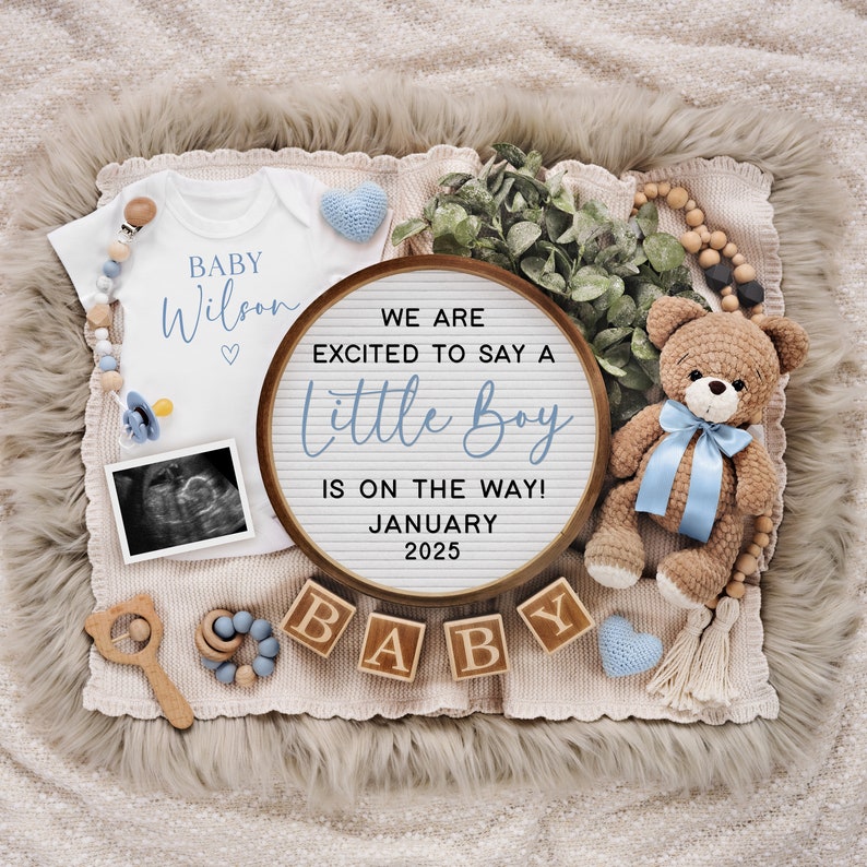 以下が含まれることがあります： 白いロンパースに「BABY Wilson」と書かれたベビー発表。木製の看板には「WE ARE EXCITED TO SAY A Little Boy IS ON THE WAY! JANUARY 2025」と書かれています。また、「BABY」と綴られた木製のブロック、テディベア、おしゃぶり、そして超音波画像も写っています。