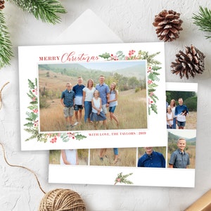May include: A Christmas card with a watercolor border of holly and berries. The card features a family photo of seven people standing in a field. The text "Merry Christmas" is written in red cursive. The text "With Love, The Taylors 2019" is written in red at the bottom of the card.