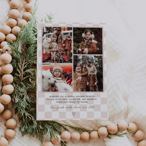 Pu&ograve; includere: Un biglietto di Natale con uno sfondo a scacchi che presenta un collage di quattro foto di una famiglia con un cane. Il testo dice "Wishing you a joyful holiday season filled with love, laughter, and warmth, from our family to yours. love jacob emily olivia and stella ♡"