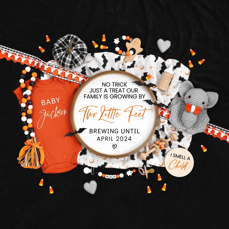 May include: A Halloween-themed baby announcement with a black and white bat print fabric, a wooden sign that reads "No trick just a treat our family is growing by two little feet brewing until April 2024", a baby onesie that says "Baby Jackson", and a variety of Halloween decorations.