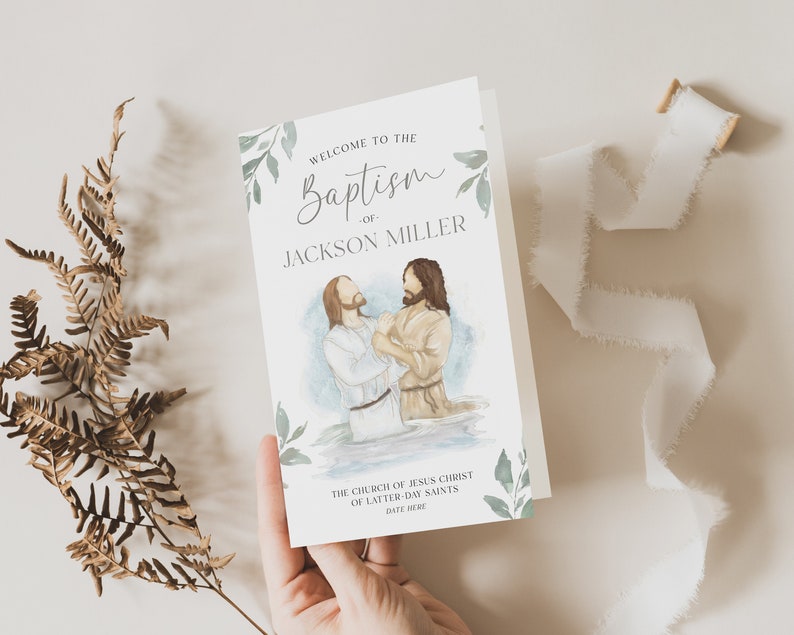 May include: A white card with green foliage and a watercolour illustration of a baptism. The text reads "Welcome to the Baptism of Jackson Miller. The Church of Jesus Christ of Latter-day Saints. Date Here."