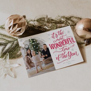 May include: A Christmas card featuring a family of three with a Christmas tree in the background. The text on the card reads "It's the most wonderful time of the year." The Sanders Family, Jack, Michelle, & Eleanor, 2023.