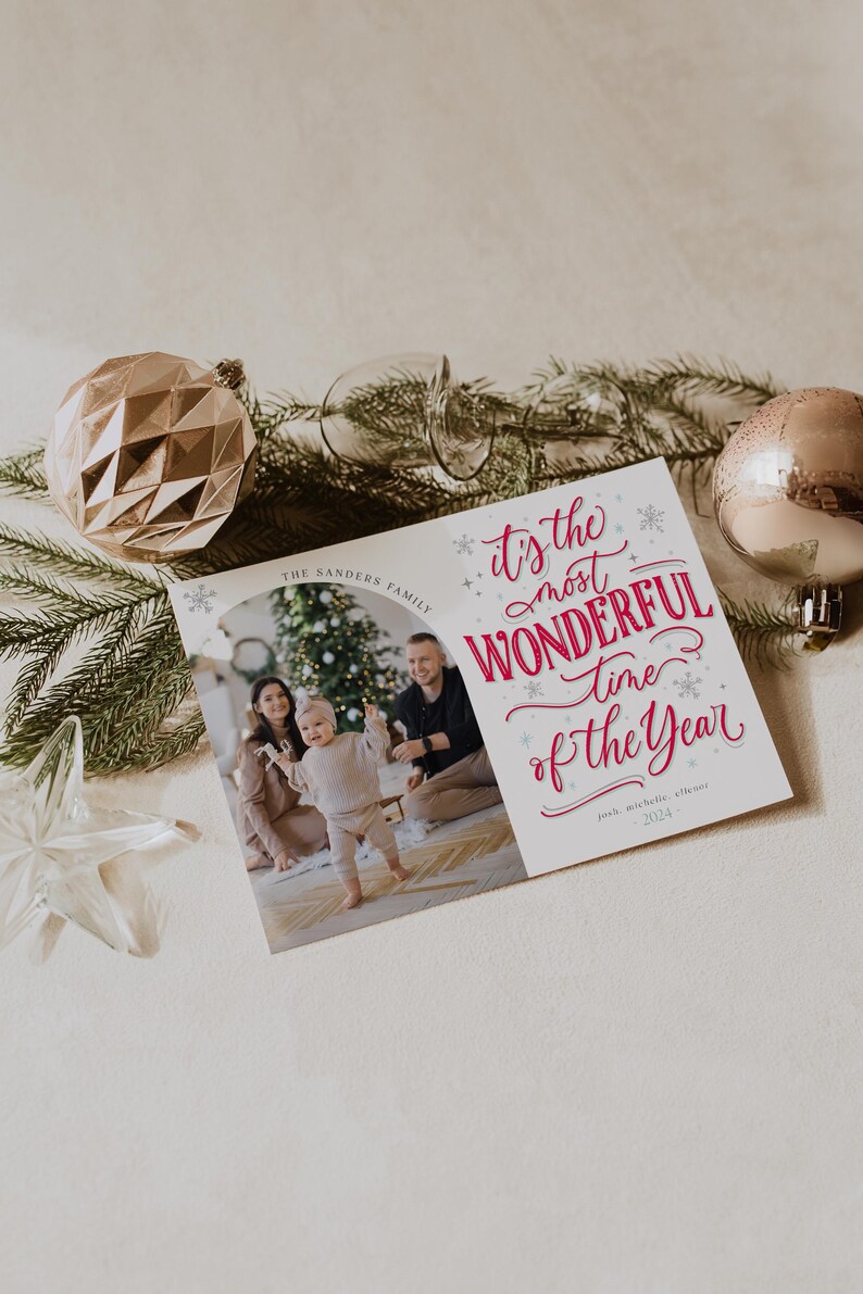 May include: A Christmas card featuring a family of three with a Christmas tree in the background. The text on the card reads "It's the most wonderful time of the year." The Sanders Family, Jack, Michelle, & Eleanor, 2023.