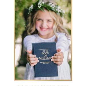 May include: A young girl wearing a flower crown holds a blue book titled "The Book of Mormon, Another Testament of Jesus Christ".