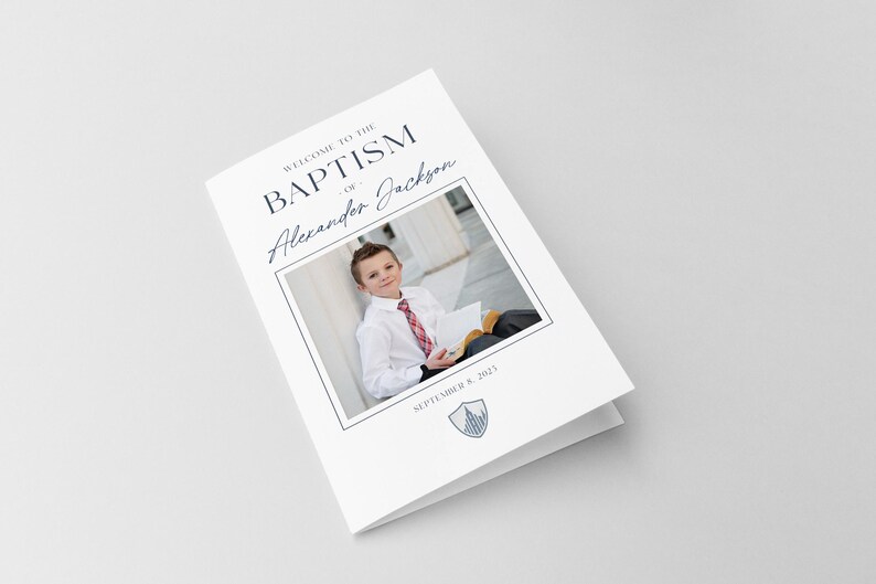 May include: A white card with the text "Welcome to the Baptism of Alexander Jackson" and a photo of a young boy in a white shirt and tie holding a book. The date "September 8, 2021" is printed below the photo.
