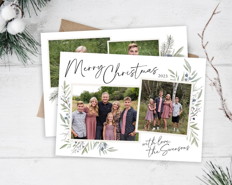 May include: A Christmas card with a watercolor design of green leaves and berries. The card features a family photo with the text "Merry Christmas 2023" and "with love, the Swensons".