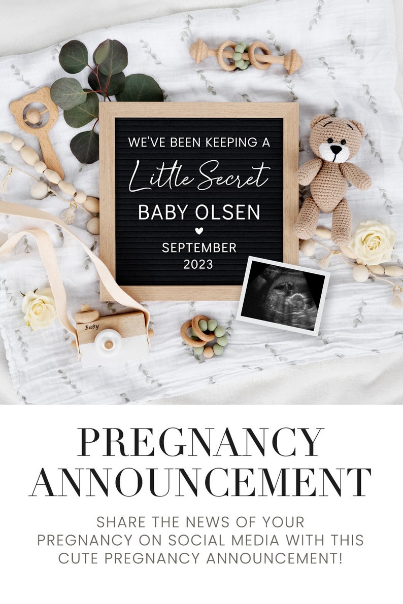 K&ouml;nnte beinhalten: Ein schwarzes Buchstabenbrett mit wei&szlig;em Text, der eine Schwangerschaft ank&uuml;ndigt. Der Text lautet "We've been keeping a little secret, Baby Olsen, September 2023". Das Brett ist von babybezogenen Gegenst&auml;nden umgeben, darunter ein Teddyb&auml;r, eine Spielzeugkamera aus Holz und ein Ultraschallbild.