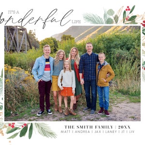 May include: A Christmas card featuring a family of six standing in front of a bridge. The card has a green and gold watercolor border with red berries. The text on the card reads "It's a Wonderful Life" and "The Smith Family 20XX".