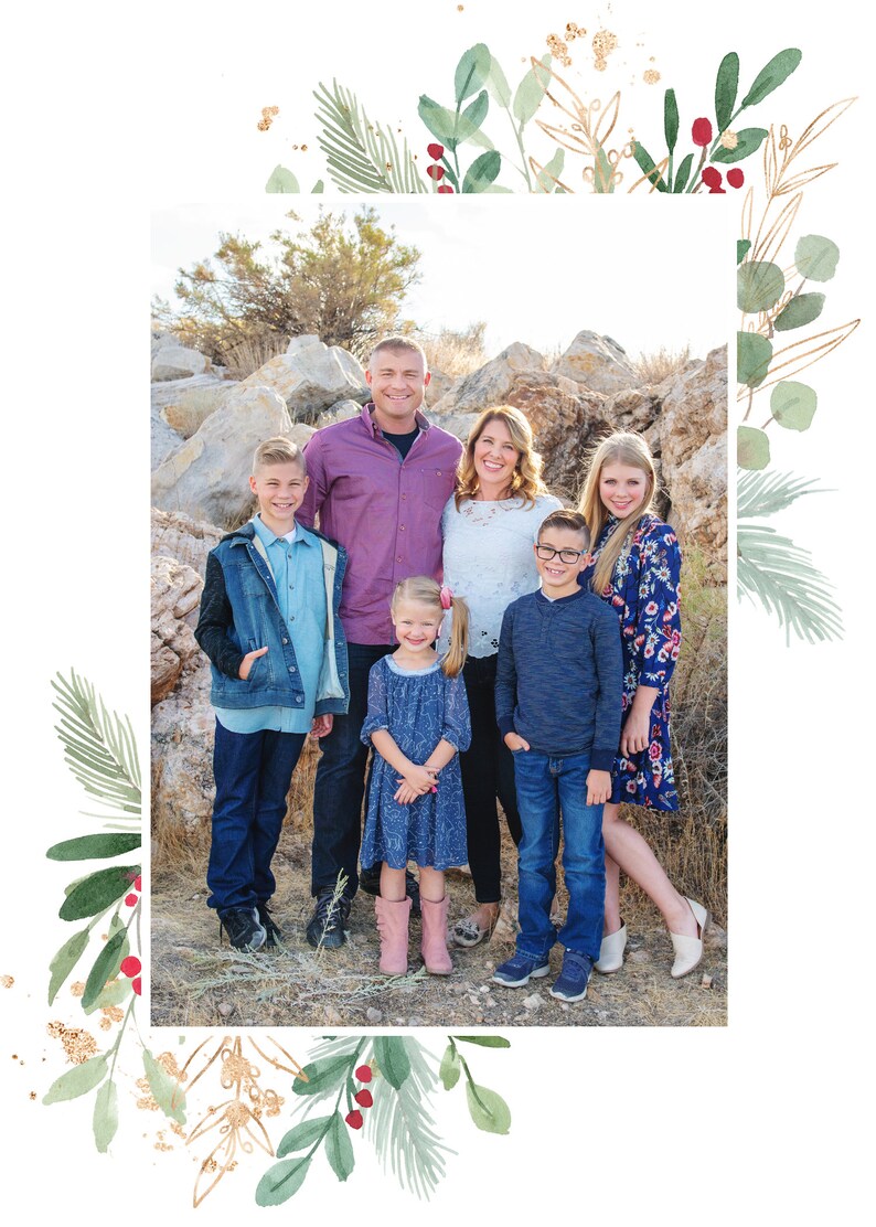 May include: A family of six poses for a photo in front of a rocky landscape. The family is dressed in casual clothing, including jeans, shirts, and dresses. The father is wearing a purple shirt, the mother is wearing a white shirt, and the children are wearing a variety of colors. The family is smiling and looking at the camera.