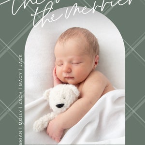 May include: A newborn baby is sleeping peacefully in a white blanket, holding a white teddy bear. The image is framed with a green and white plaid pattern and the text "the more the merrier" and "The Smith Family twenty twenty-two" is visible.