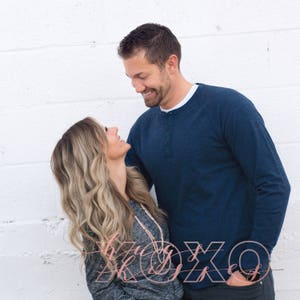 May include: A couple looks at each other and smiles. The man is wearing a blue long-sleeved shirt and the woman is wearing a gray shirt. The text "XOXO Kisses" is written in pink cursive letters on the bottom of the image.