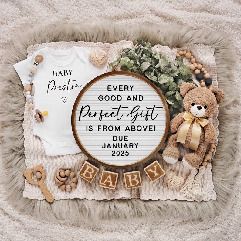 May include: A wooden sign with the text "Every good and perfect gift is from above! Due January 2025" surrounded by baby items including a onesie, a teddy bear, wooden blocks spelling "BABY", and a wooden bead garland.