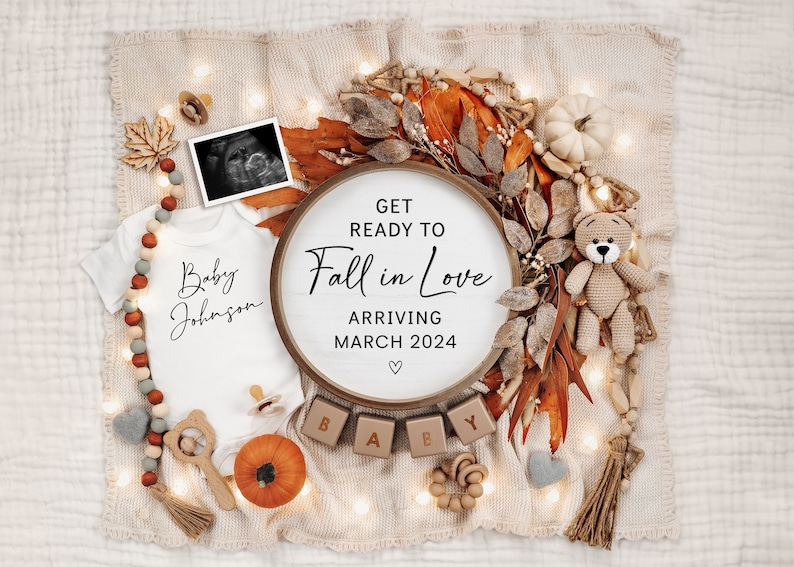 May include: A baby announcement with an autumn theme. A white babygrow with the text "Baby Johnson" is surrounded by autumn leaves, a wooden sign that says "Get Ready to Fall in Love Arriving March 2024", and wooden blocks that spell out "BABY".
