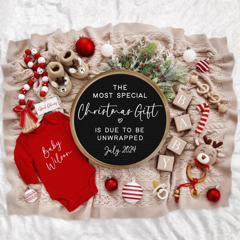 Pu&ograve; includere: Una lavagna nera con la scritta "The most special Christmas gift is due to be unwrapped July 2024". La lavagna &egrave; circondata da decorazioni natalizie rosse e bianche, un body da bambino rosso con la scritta "Baby Wilson" e blocchi di legno che compongono la parola "Baby".