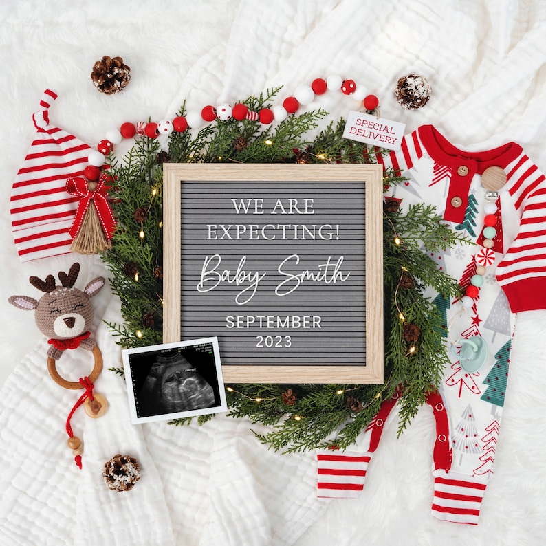 May include: A Christmas-themed pregnancy announcement with a letter board that reads "We are expecting! Baby Smith September 2023". There is a red and white striped stocking, a baby onesie with a Christmas tree design, a sonogram image, and a garland of red and white beads.