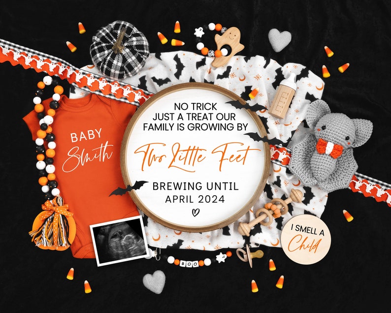 May include: A Halloween-themed baby announcement with a white embroidery hoop that reads "No trick just a treat our family is growing by two little feet brewing until April 2024."  The hoop is surrounded by a variety of Halloween decorations, including a baby onesie, a pacifier, a rattle, a stuffed bat, and candy corn.