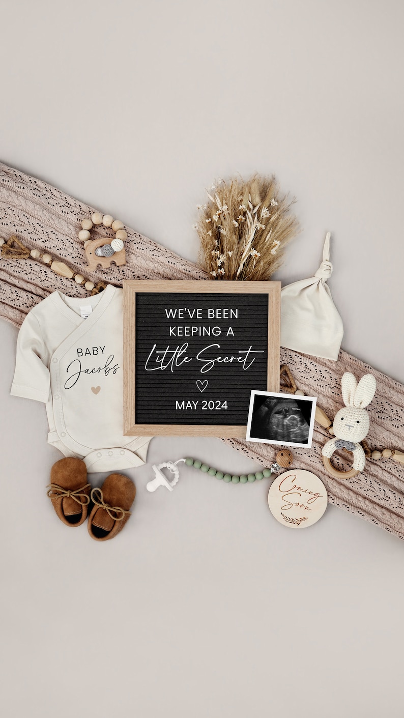 Puede incluir: Un anuncio de embarazo con un tablero de letras que dice "We've Been Keeping A Little Secret May 2024". El anuncio incluye un body de beb&eacute; que dice "Baby Jacobs", un par de zapatos de beb&eacute; marrones, un sonajero de madera, un c&iacute;rculo de madera que dice "Coming Soon", un chupete, un collar de cuentas, una manta de punto, un conejito de peluche, un gorro de beb&eacute; y una imagen de ultrasonido.