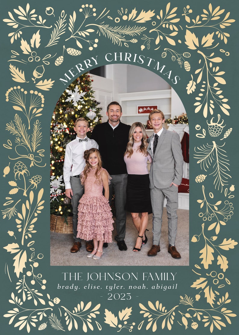 May include: A Christmas card featuring a family of five standing in front of a decorated Christmas tree. The card has a green background with gold floral designs and the text "Merry Christmas" and "The Johnson Family" in a gold font. The text "brady. elise. tyler. noah. abigail" and "2023" are also included in gold font.