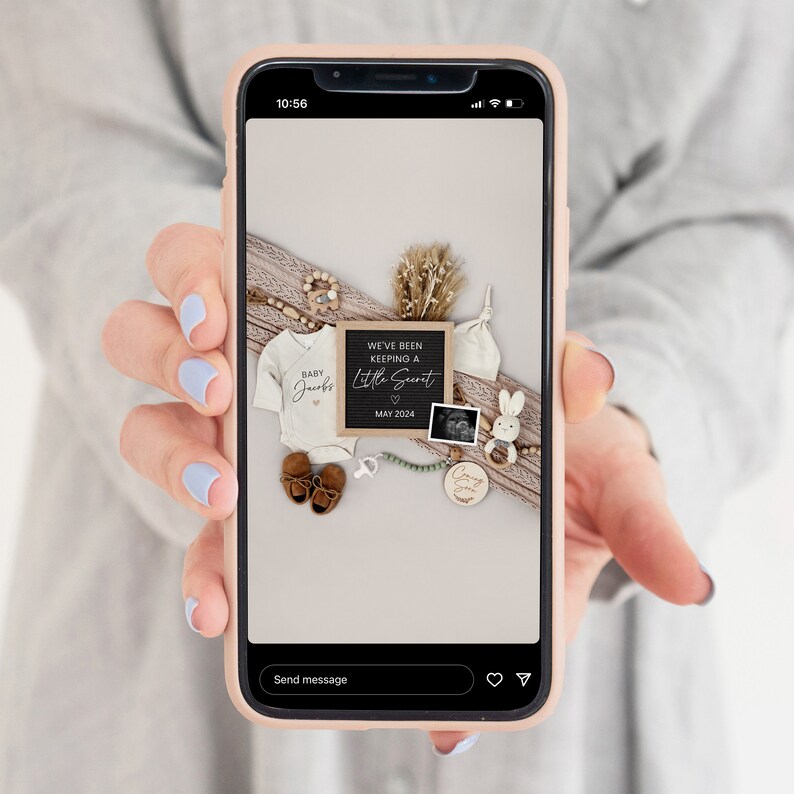 Puede incluir: La pantalla de un tel&eacute;fono que muestra una foto de un anuncio de nacimiento. La foto incluye un body blanco con el texto "Baby Jacobs", un letrero de pizarra que dice "We've been keeping a little secret, May 2024", un letrero de madera que dice "Coming Soon", un sonajero de madera con forma de conejo y un peque&ntilde;o collar de cuentas de madera.