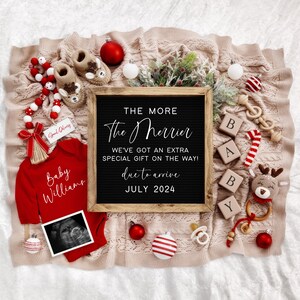 Puede incluir: Un anuncio de nacimiento con tem&aacute;tica navide&ntilde;a con un letrero de pizarra que dice "The More The Merrier We've Got An Extra Special Gift On The Way! Due To Arrive July 2024". El letrero est&aacute; rodeado de patucos de beb&eacute;, un mameluco rojo con el texto "Baby Williams", un bast&oacute;n de caramelo, un bloque de madera que deletrea "BABY" y otras decoraciones navide&ntilde;as.