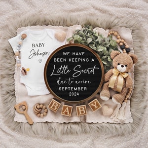 May include: A baby announcement featuring a white onesie with "BABY Johnson" printed on it, a letter board with the text "WE HAVE BEEN KEEPING A Little Secret due to arrive SEPTEMBER 2024", wooden blocks spelling "BABY", and a teddy bear.