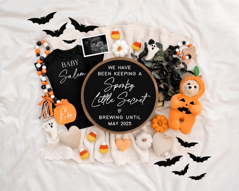 Puede incluir: Un tablero de letras blanco y negro con el texto "We have been keeping a Spooky Little Secret. Brewing until May 2025." El tablero est&aacute; rodeado de decoraciones de Halloween, incluyendo un mameluco negro con el texto "Baby Salem", un juguete de peluche con forma de calabaza y un oso de peluche con un disfraz de calabaza.