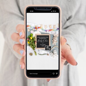 K&ouml;nnte beinhalten: Ein Telefonbildschirm zeigt eine Schwangerschaftsanzeige mit einem Schild aus Schiefer, auf dem "We're eggspecting somebunny! Baby Olsen October 2024" steht. Das Schild ist von einer bunten Girlande, Blumen, einem Hasenspielzeug und Babyschuhen umgeben.