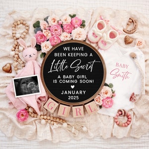 K&ouml;nnte beinhalten: Eine rosa-wei&szlig;e Baby-Ank&uuml;ndigung mit einer Buchstaben-Tafel, auf der steht "We have been keeping a little secret. A baby girl is coming soon! January 2025". Die Buchstaben-Tafel ist umgeben von rosa Blumen, einem Baby-Strampler, einem Paar Stiefelchen und einem Ultraschallbild.