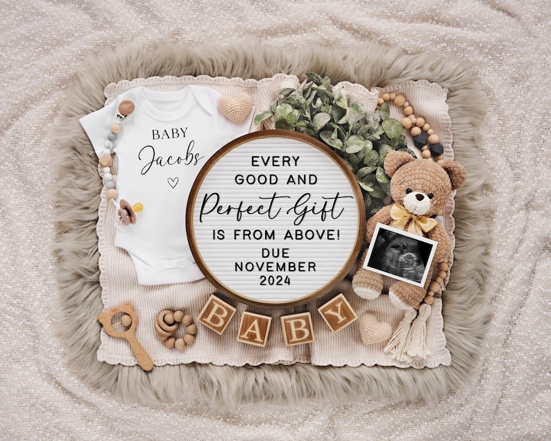 May include: A white onesie with the text "BABY Jacobs" and a heart. A letter board with the text "EVERY GOOD AND Perfect Gift IS FROM ABOVE! DUE NOVEMBER 2024". Wooden blocks spelling "BABY". A teddy bear holding a sonogram image.