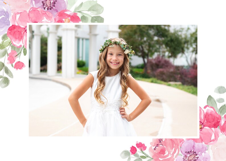 May include: A young girl wearing a white dress and a flower crown smiles for the camera. She is standing in front of a white building with columns.