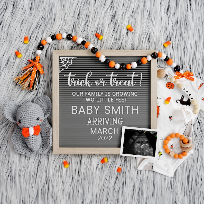 May include: A Halloween-themed baby announcement with a letter board that reads "trick or treat! Our family is growing two little feet Baby Smith arriving March 2022". There is a crocheted bat, a sonogram photo, and a baby onesie with a pumpkin and ghost design.