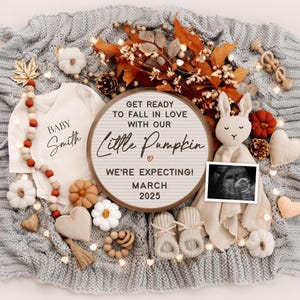K&ouml;nnte beinhalten: Eine Baby-Ank&uuml;ndigung im Herbst-Stil mit einem wei&szlig;en Strampler, auf dem "Baby Smith" steht, und einer Buchstabentafel mit der Aufschrift "Mach dich bereit, dich in unsere kleine K&uuml;rbis zu verlieben. Wir erwarten ein Baby! M&auml;rz 2025".